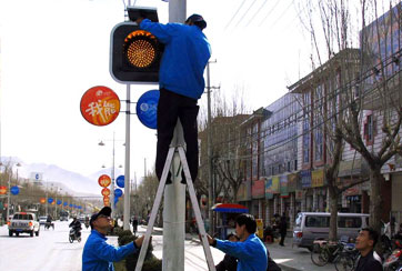 2006年3月22日，西藏凯发k8公司员工正在安装向拉萨捐赠太阳能交通指示灯